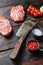 Old butcher knife cleaver near top blade organic meat cut, raw marbled beef steak, and seasonings  On dark wooden rustic table,