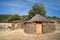 Old cabin or hut with a round shape and slate stone walls and a broom and straw roof