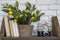 An old camera with books, clocks and artificial lemon tree on a shelf with white bricks background.