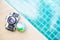 Old camera with global ball on swimming pool edge with space on blue background