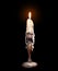 Old candle with dripping wax, isolated on black.