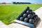 Old cannonballs stacked in pyramid, in front of cannons, on Valletta Castle, Malta