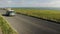 Old car speeding on a country road, Dorset, England, with green fields and the sea in the backgroun