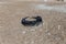 Old car tires on the beach,Water and sea coast pollution car tires on sand beach,An image of an old car tire ingrown into the sand