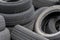 Old car tires, worn tread, worn rubber, a pile of old car wheels, a dump of worn tires from used cars. Environmental pollution