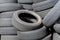Old car tires, worn tread, worn rubber, a pile of old car wheels, a dump of worn tires from used cars. Environmental pollution