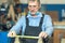 An old carpenter with a mustache and glasses is concentrating on his work.