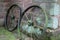 Old cart wheels rusting propped up against a wall