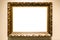Old carved wide bronze picture frame on brown wall