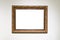 Old carved wide bronze picture frame on white wall