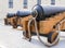 Old cast-iron artillery guns stand in a row, rear view perspective