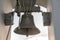 An old cast-iron bell hangs on a wooden frame at the top of the bell tower. A historical building with a religious purpose