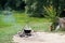 Old cast-iron cauldron on a fire. Cooking food outdoors in a pot on a tripod. Ax in a wooden stump