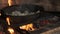 old cast-iron skillet with fried onions stands on stove. Flames close up footage. concept of frying vegetables in pan at