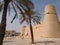 Old castle in Riyadh near the Municipality, national flag of Saudi Arabia Kingdom in front of castle towers , palms around