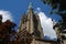 Old Cathedral spire reaching into the blue sky and pristine white clouds