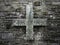 Old catholic cross on a dark stone background. Central position in the frame. Religion and faith through time concept