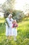 Old caucasian granny standing with little granddaughter and keeping flowers.