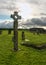 Old celtic stone cross on cemetery full of green grass