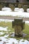 Old cemetary in winter with stone cross