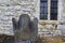 Old cemetery stone with worn engraving,resting against outside wall of famous St.Mary\'s Cathedral,Limerick,Ireland,October 2014