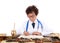 An old Chinese doctor in a white coat reads carefully on a table full of herbs