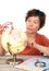 An old Chinese lady carefully looking at the globe in front of a white background