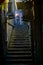 An old Chinese lady with an umbrella in a mysterious back alley and staircase in the Taiwanese village of Jiufen