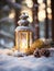 Old christmas candle lantern in snow against blurred forest background. Selective focus and shallow depth of field