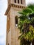 Old church clocktower with a big palm tree in front of it, Crete, Greece