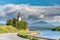 Old church at the left side of Umea river, heavy rainy clouds and mountain range at background. E12 european road curves at the