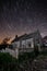 Old church at night with star trails