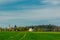 Old church and palace near forest and green spring wheat field