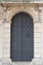Old church textured door with stone arch facade. Krakow