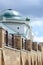 Old church with turquoise dome behind contemporary fence