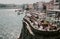 Old city houses over Douro river and many tourists having lunch at outdoor restaurant