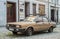 Old classic scrap rusty veteran sedan car Audi 80 parked