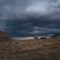 Old climbing house in the mountains under a stormy sky. Empty mountaineering camp. Authentic mountain dramatic landscape in the