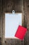 Old clipboard, red notebook on grungy wooden surface