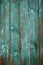 Old close boarded fence painted with sun-faded green color, text