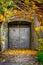 Old closed grungy steel door underground entrance outdoors covered with colorful autumn leafs.