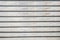 Old closed shabby horizontal long-painted wooden blinds