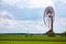 An old, closed wind farm standing alone in a field. Object against the sky with tiny clouds.