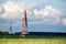 An old, closed wind farm standing alone in a field. Object against the sky with tiny clouds