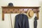 Old coat rack with umbrella, hat and coat.