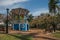 Old colorful gazebo and lighting pole in the middle of verdant garden full of trees, in a sunny day at SÃ£o Manuel.