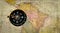 Old compass on antique cracked world map. Vintage still life. Top view