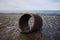 Old concrete circular pipe on the beach