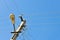 Old concrete electric pole for transmission of wired electricity with lamp post on a background of a cloudy blue sky. Obsolete me