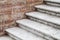 Old concrete stairway goes near brick wall